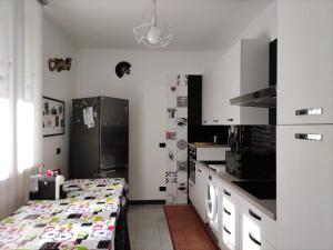 a kitchen with a table and a refrigerator at B&B Ariosto 26 in Rho