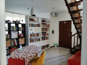 a dining room with a table and bookshelves at B&B Ariosto 26 in Rho