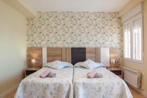 1 dormitorio con 1 cama con 2 almohadas rosas en The View - Apartamento reformado con vistas a la Catedral - leonapartamentos, en León