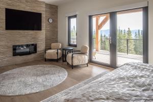 a bedroom with a fireplace and a tv on a wall at Skylark Chalet in Big Sky