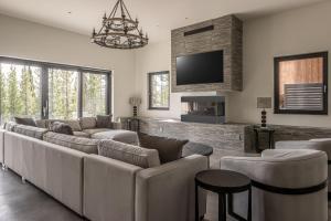 a living room with couches and a flat screen tv at Skylark Chalet in Big Sky