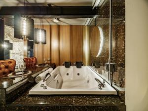 a bathroom with a large tub in a room at Hotel One Laureles in Medellín