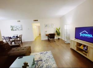 a living room with a television and a dining room at Bayview Regency Apartments By Lowkl in Fort Lauderdale