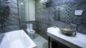 a bathroom with a sink and a shower and a toilet at Nemi Museum Hotel Baku in Baku
