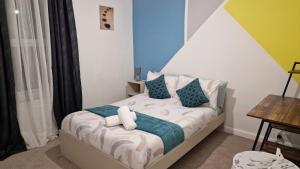 um quarto com uma cama azul e branca em Saxon Street House em Gillingham