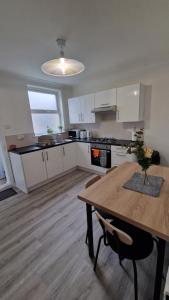 uma cozinha com uma mesa de madeira e uma sala de jantar em Saxon Street House em Gillingham