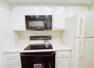 a kitchen with a stove and a microwave at Bayview Regency Apartments By Lowkl in Fort Lauderdale