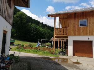 a wooden house with a garage and a fence at Ferienwohnungen Dopplerhof in Piding