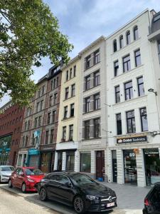 una fila di edifici su una strada di città con auto parcheggiate di Royal South - Apartment Antwerp with Parkview ad Anversa