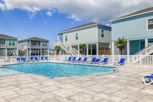een zwembad met blauwe stoelen en huizen bij Breezy Cottage in Rockport