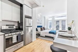 a kitchen and living room with a bed in a room at Studio w Charming Juliet Balcony in Upper East in New York