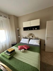 - une chambre avec un lit vert et 2 oreillers dans l'établissement Suite Emilia, à SantʼIlario dʼEnza