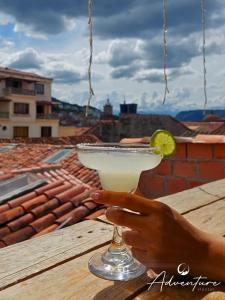 a person holding a margarita with a lime on a table at ADVENTURE Hostel in San Gil