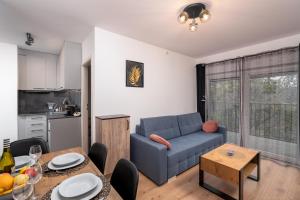 - un salon avec un canapé bleu et une table dans l'établissement ApartWro 3th - apartament przy dworcu głównym PKP, balkon, garaż, rowery, à Wrocław