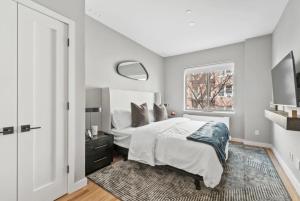 een witte slaapkamer met een bed en een raam bij Top Notch 2BR Suite Minutes to Central Park in New York