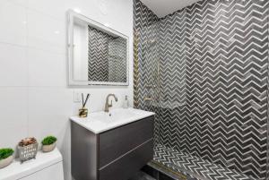 baño con lavabo y pared a cuadros en Top Notch 2BR Suite Minutes to Central Park, en Nueva York