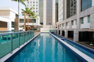 a swimming pool in a city with buildings at Jade Hotel Brasília in Brasilia