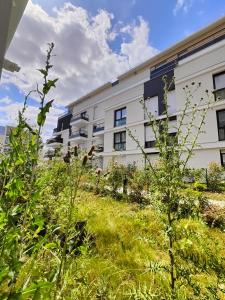 ein Gebäude mit einem Grasfeld davor in der Unterkunft l'Éden familial - cosy T3 proche Disneyland avec jardin in Vaires-sur-Marne