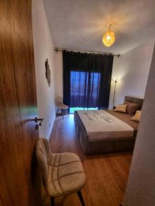 - une chambre avec un lit, une chaise et une fenêtre dans l'établissement Luxury Golf-Marrakech Apartment, à Marrakech
