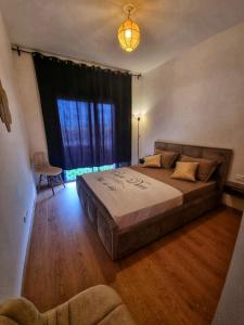 - une chambre avec un grand lit et une grande fenêtre dans l'établissement Luxury Golf-Marrakech Apartment, à Marrakech