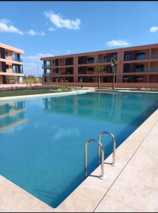 une grande piscine en face d'un bâtiment dans l'établissement Luxury Golf-Marrakech Apartment, à Marrakech