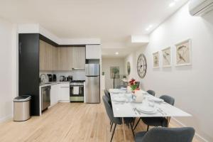 a dining room and kitchen with a white table and chairs at Luxury 2BR Duplex 5min to Central Park in New York