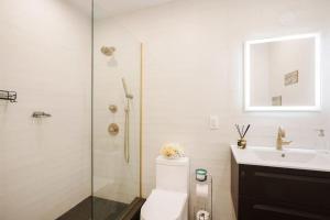 a bathroom with a shower and a toilet and a sink at Luxury 2BR Duplex 5min to Central Park in New York