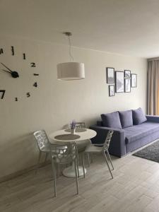 a living room with a couch and a table and chairs at Apartament Czarna Góra in Sienna