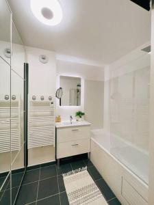 een witte badkamer met een douche en een wastafel bij Cosy Penthouse - Large balconies with views - 5min Disneyland in Serris