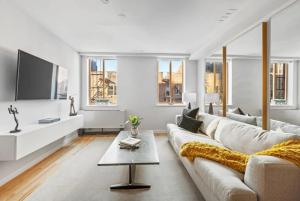 a white living room with a couch and a tv at 3BR Penthouse with Massive Private Rooftop in New York