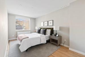 a white bedroom with a large bed and a window at 3BR Penthouse with Massive Private Rooftop in New York