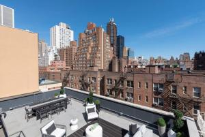 a rooftop patio with tables and chairs on a building at 3BR Penthouse with Massive Private Rooftop in New York