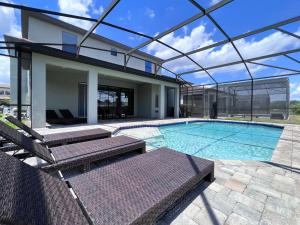 een zwembad met twee stoelen en een huis bij Balmoral Resort-140AA in Haines City