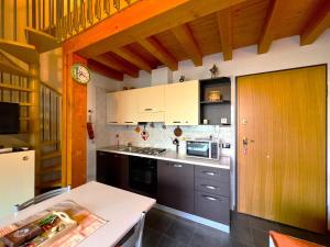a kitchen with white cabinets and a counter top at Affittimoderni San Simone - Appartamento Sci Sole in Valleve
