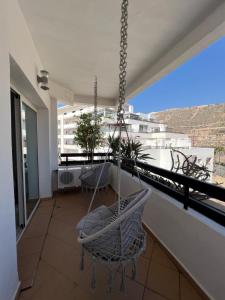 a porch with chairs and a hammock on a balcony at Magnifique appartement a la marina d agadir in Agadir