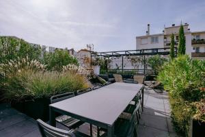 einen Tisch und Stühle auf einer Terrasse mit Pflanzen in der Unterkunft Luxury house for 8 - 3 terraces - By Askmefrance in Boulogne-Billancourt