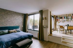 1 Schlafzimmer mit einem blauen Bett und einem Esszimmer in der Unterkunft Luxury house for 8 - 3 terraces - By Askmefrance in Boulogne-Billancourt