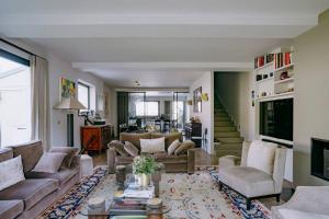 ein Wohnzimmer mit einem Sofa, Stühlen und einem Tisch in der Unterkunft Luxury house for 8 - 3 terraces - By Askmefrance in Boulogne-Billancourt
