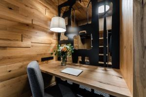 Pokój z drewnianą ścianą i biurkiem z laptopem w obiekcie Rezidence Alpina w Szpindlerowym Młynie