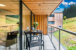 a balcony of a house with a table and chairs at Rezidence Alpina in Špindlerův Mlýn