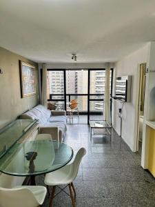 een woonkamer met een bank en een tafel bij Flat Atlântico Neto in Fortaleza