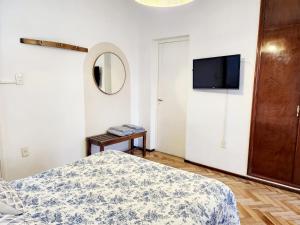 Schlafzimmer mit einem Bett und einem Flachbild-TV in der Unterkunft Casa del Buen Viaje in Mendoza
