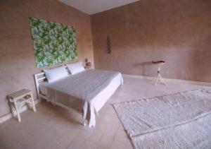 a bedroom with a large bed and two rugs at RIAD AMAN SKOURA in Skoura