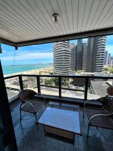 - un balcon avec des chaises et une table donnant sur l'océan dans l'établissement Flat Atlântico Neto, à Fortaleza