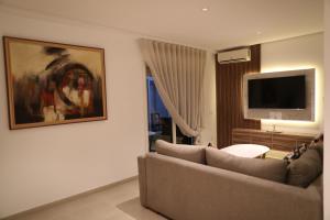 uma sala de estar com um sofá e uma televisão de ecrã plano em Cozy Apartment with Veranda Downtown em Casablanca