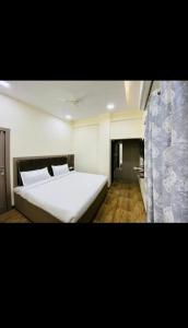 a bedroom with a large white bed and a curtain at HOTEL THE VILLA in Bhopal