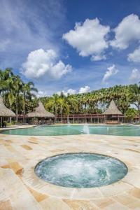 a pool at a resort with palm trees at HOTEL CAMPESTRE Palma in Villavicencio