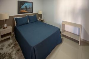 een slaapkamer met een blauw bed met blauwe lakens bij Flat inteiro Ônix Bueno in Goiânia