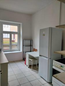 a kitchen with a white refrigerator and a table at City Home Zurich in Zürich