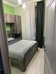 ein Schlafzimmer mit einem Bett und grünen Wänden in der Unterkunft Comfy Apartment in Center in Yerevan